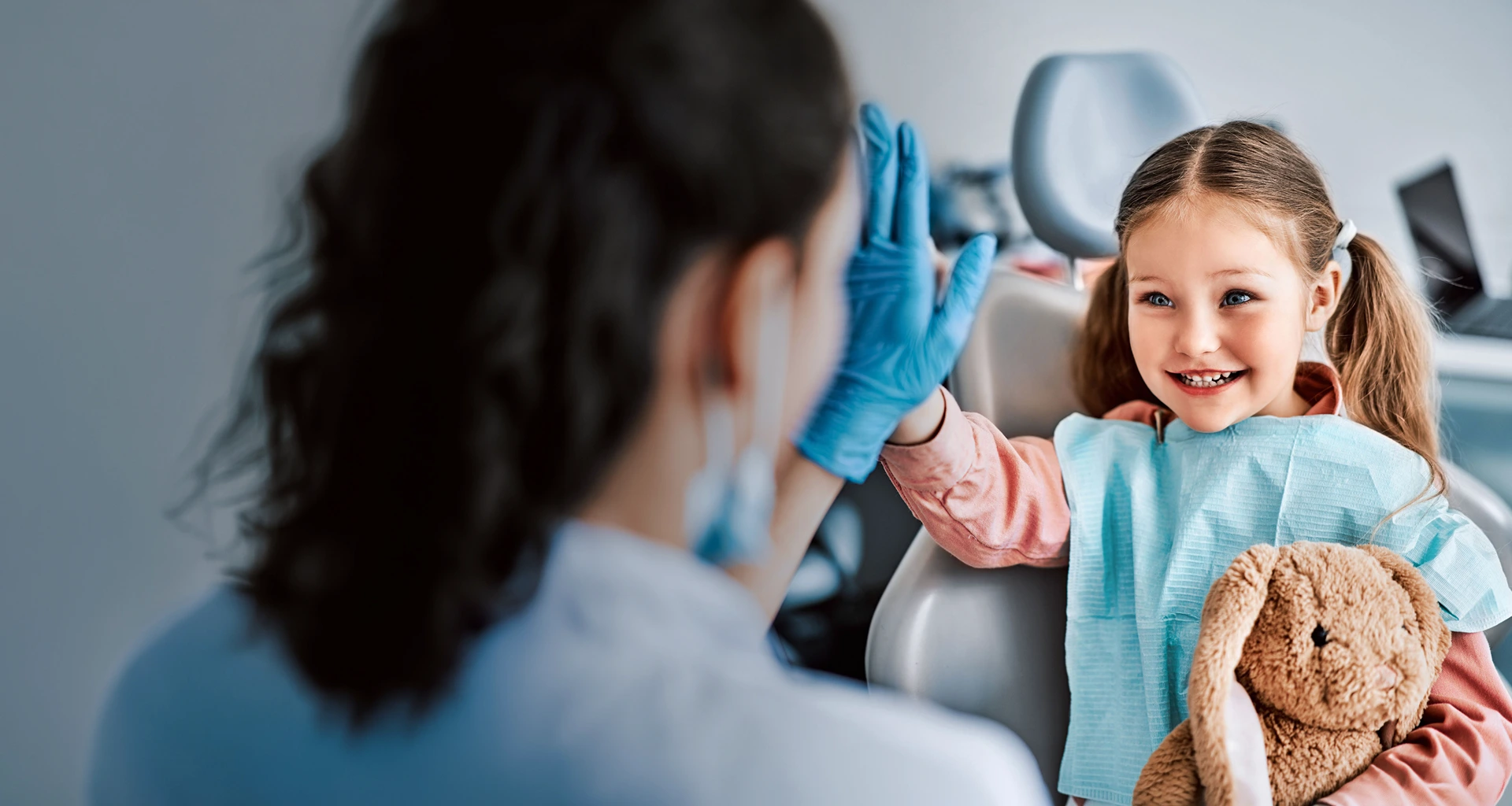 Young girl and dentist doing high five